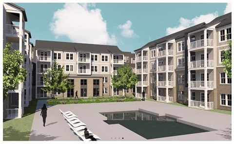 A person walks on a pathway in front of apartment buildings.