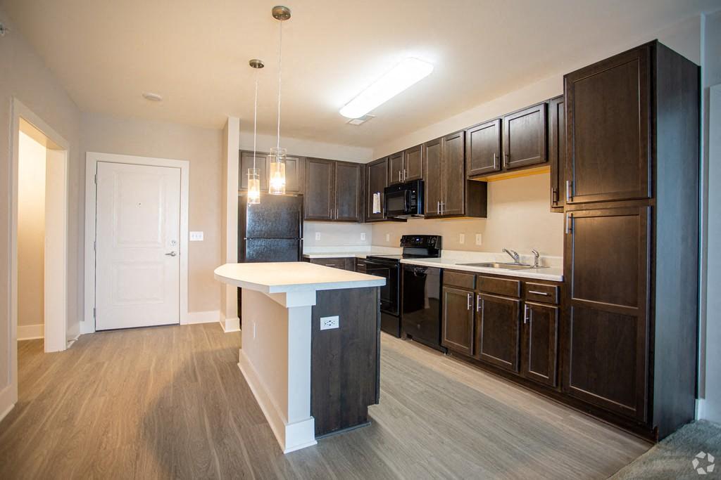 A kitchen with dark brown cabinets and a white island.