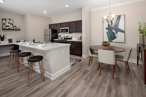 A modern kitchen with a bar area and a dining table.