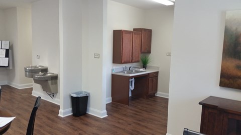 a small kitchen with a sink and a toilet in a room