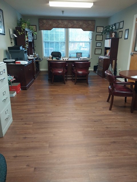 A room with wood floors and furniture.