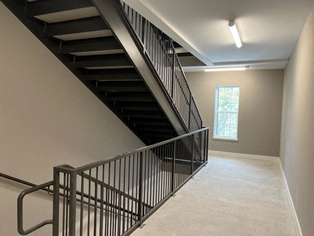 a staircase in a building with a railing and a window