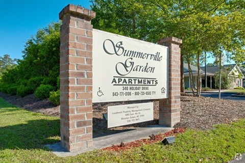 A sign for Summerville Garden Apartments is displayed in front of a building.