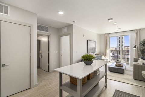 A modern kitchen with a white countertop and a large window.