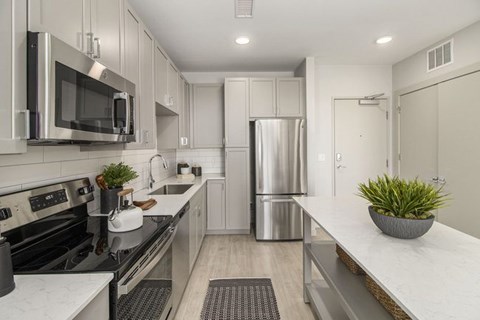 A modern kitchen with stainless steel appliances and white cabinetry.