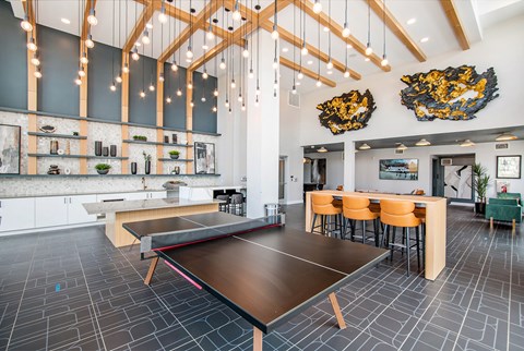 A modern kitchen with a long table and chairs.