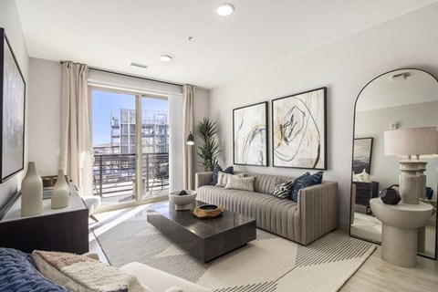 A modern living room with a large window and a view of a building outside.
