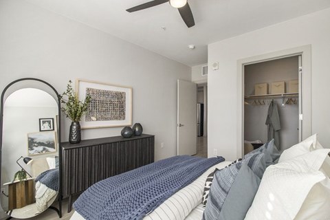A bedroom with a bed, dresser, and mirror.