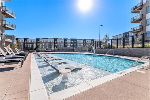 A sunny day at the pool with a fountain in the middle.