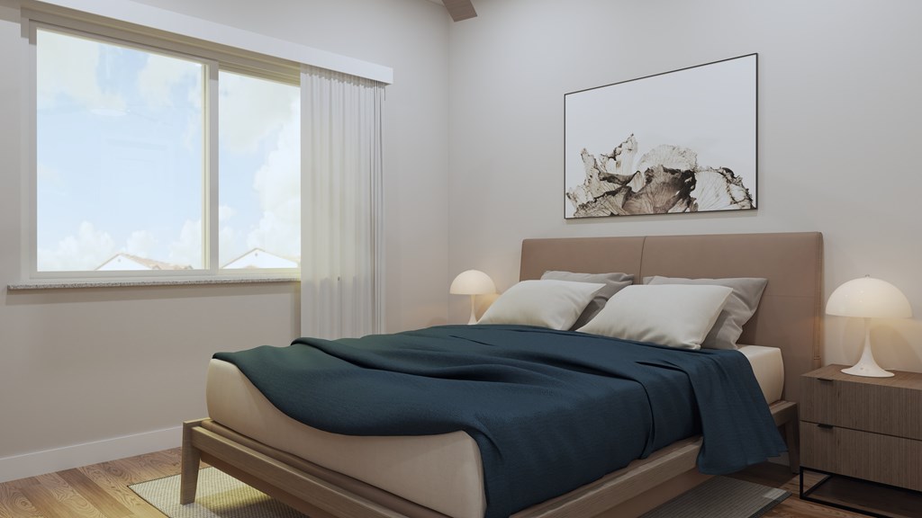 A bedroom with a bed, nightstand, and a window with a view of the sky.