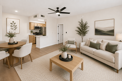 A living room with a couch, coffee table, and a dining table.