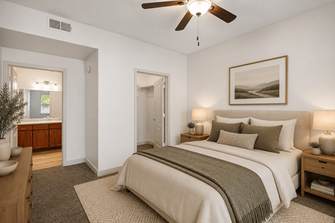 A bedroom with a large bed and a ceiling fan.