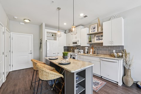 A kitchen with a table and chairs in the middle of it.