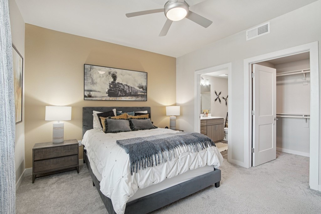 A bedroom with a bed, nightstands, and a painting on the wall.