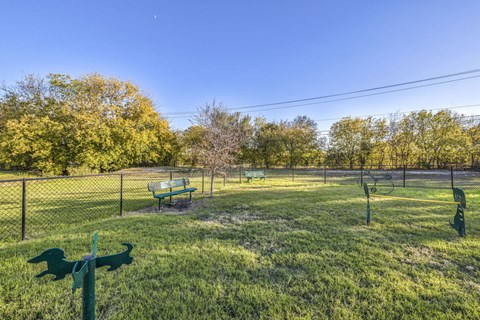 A park with a green bench and a signpost.