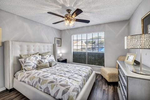 A bedroom with a large bed and a ceiling fan.