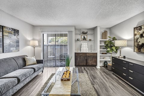 A modern living room with a grey sofa and a wooden coffee table.