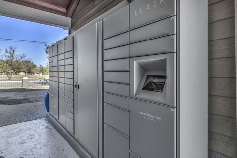 A row of LUXER branded lockers are lined up on a sidewalk.