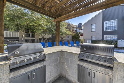 Outdoor kitchen with two grills and a built-in sink.