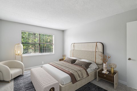 A bedroom with a large bed and a chair.