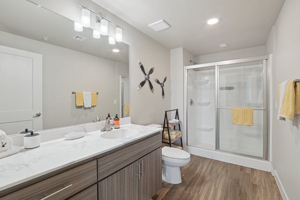 A bathroom with a white sink, toilet, and a mirror.