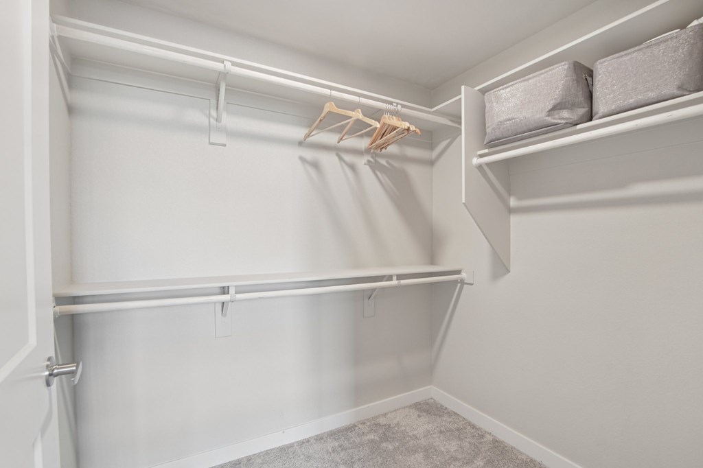 A white closet with a hanger and a shelf.
