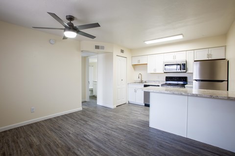 A kitchen with white cabinets and a countertop with a microwave and oven.