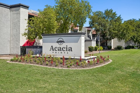 A sign that says Acacia Pointe in front of a building.
