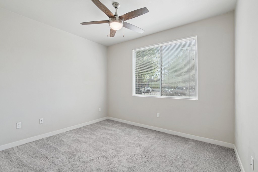 A room with a ceiling fan and a window.