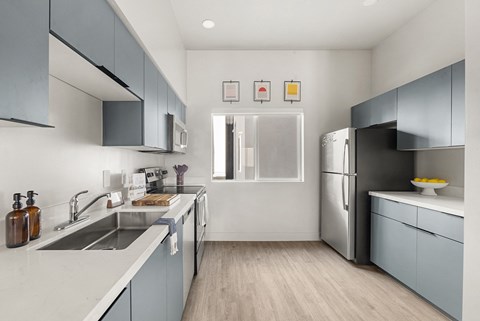 a kitchen with blue cabinets and a sink and a refrigerator