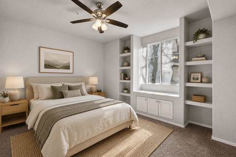 A bedroom with a bed, nightstands, and a ceiling fan.