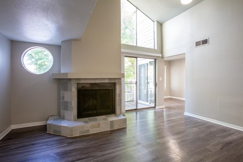 A modern living room with a fireplace and a round window.