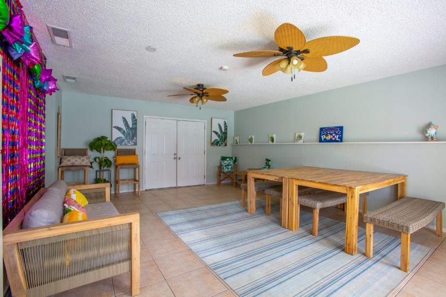A room with a ceiling fan and a dining table.