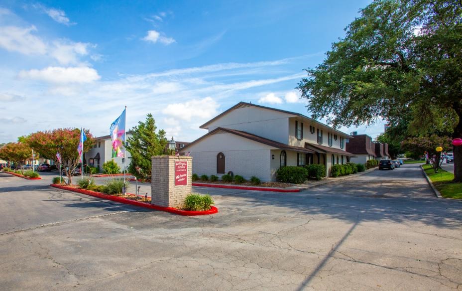 A building with a red brick pillar in front of it.