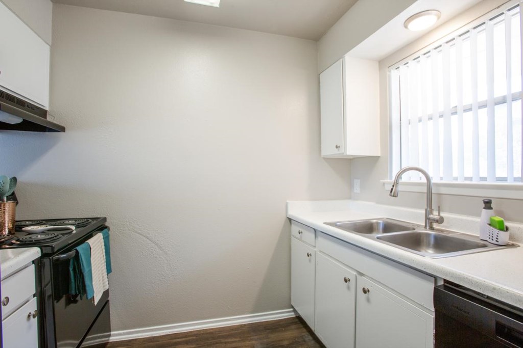 A kitchen with white cabinets and a black stove top oven.