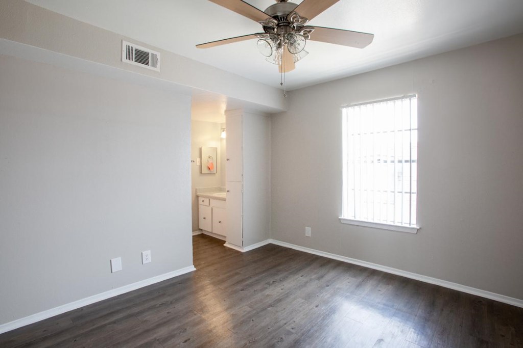 A room with a ceiling fan and a window.
