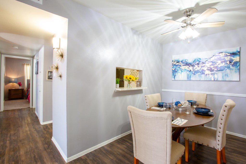 A dining room with a table set for four.