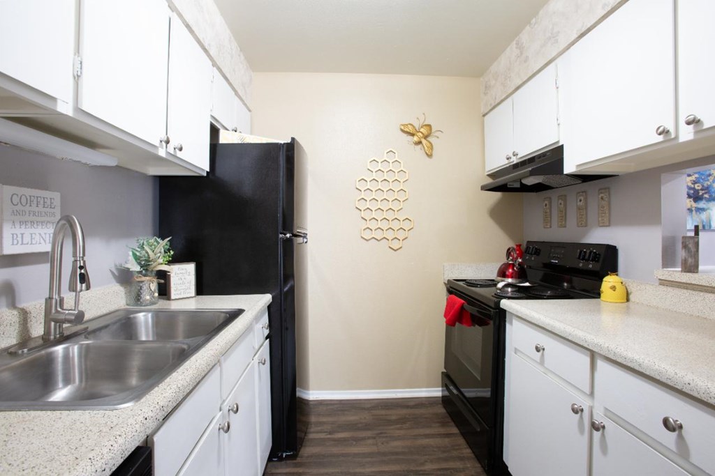 A kitchen with black appliances and white cabinets.