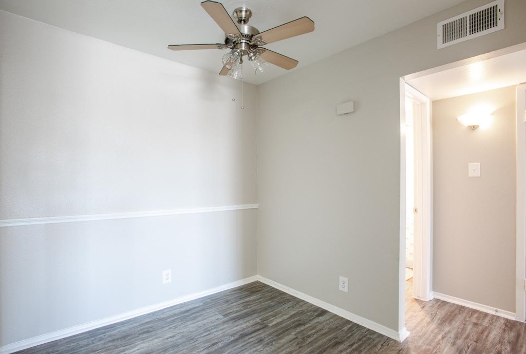 A room with a ceiling fan and light fixture.