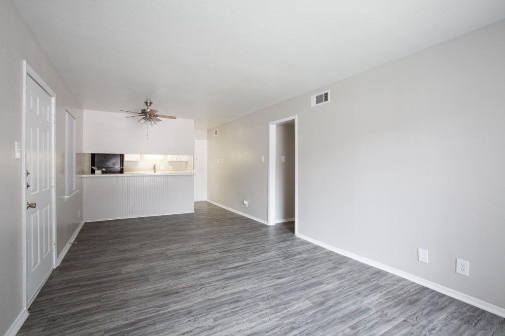 A room with a ceiling fan and a television on the wall.