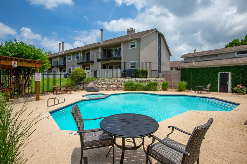 A small round table is surrounded by chairs in a backyard.