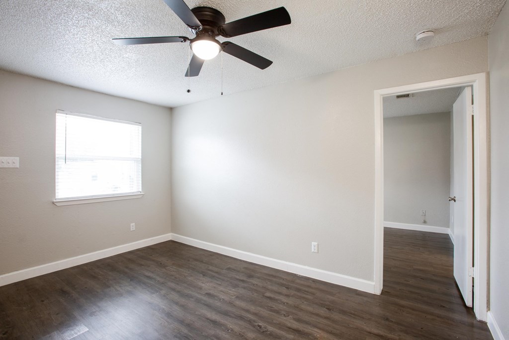 A room with a ceiling fan and a window.