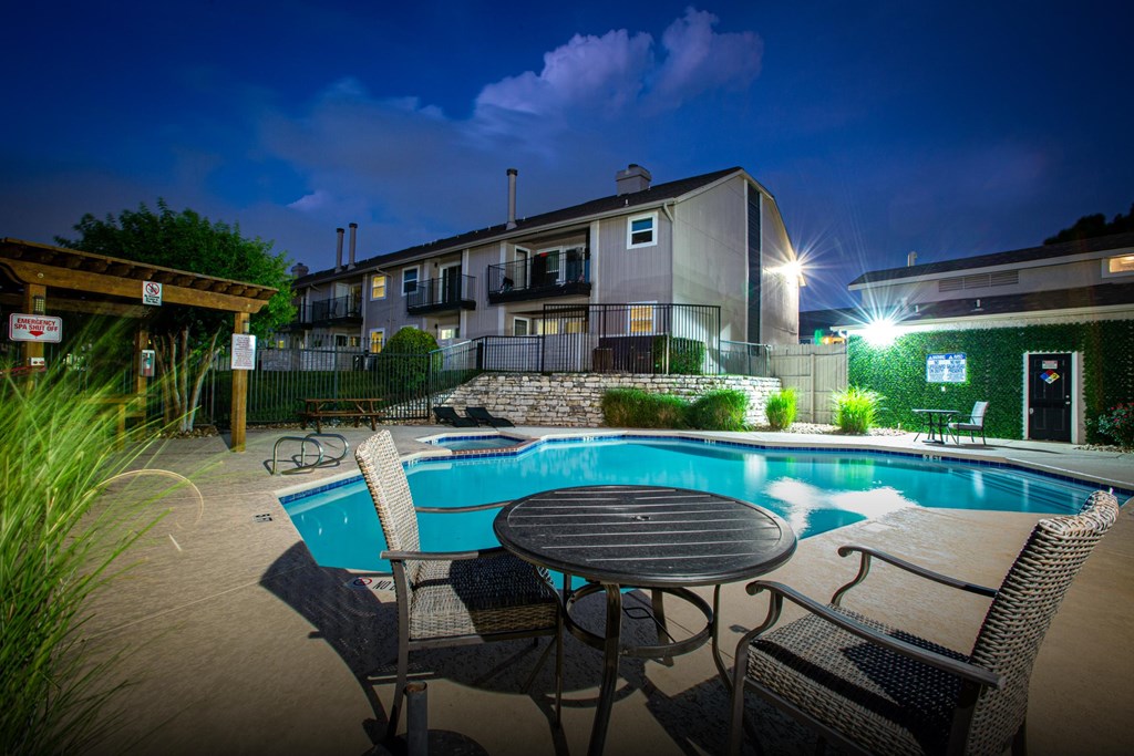 A pool area with a table and chairs.