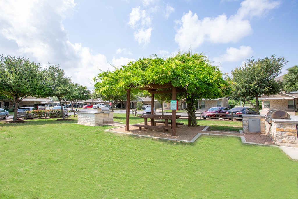 A park with a gazebo and a bench.