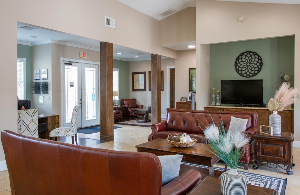 A living room with a brown leather couch and a wooden coffee table.