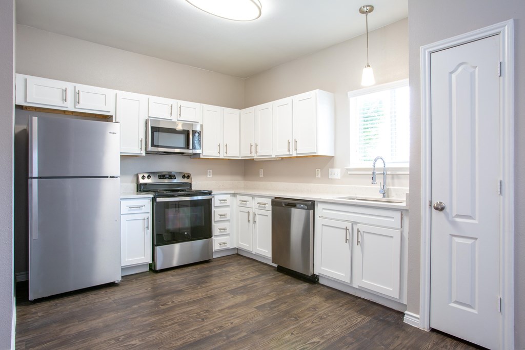 A kitchen with white cabinets and stainless steel appliances.