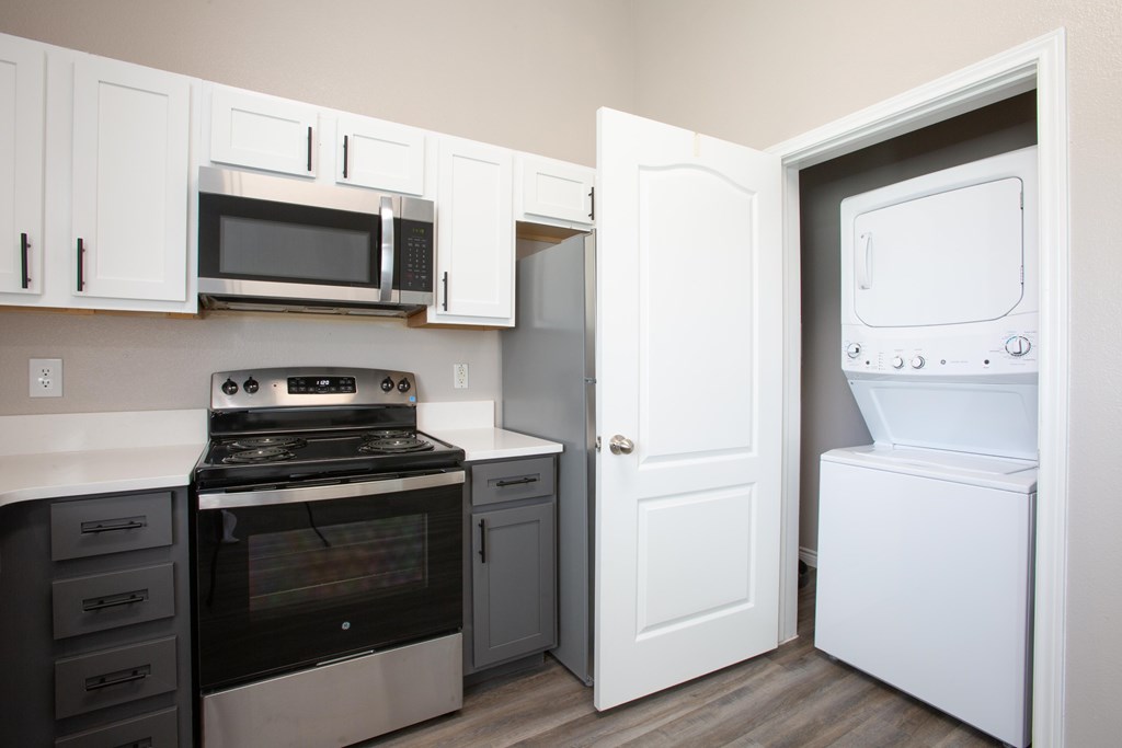 A kitchen with a white oven and microwave.