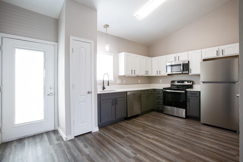A kitchen with white cabinets and stainless steel appliances.
