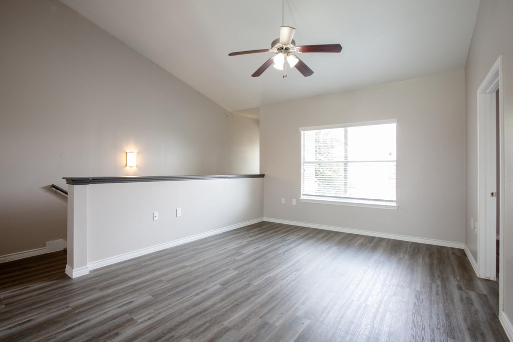 A room with a ceiling fan and a window.