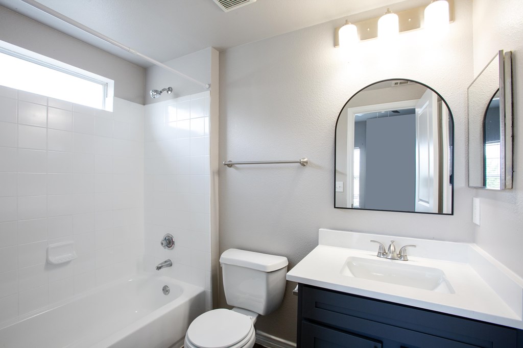 A white toilet sits next to a white sink in a bathroom.